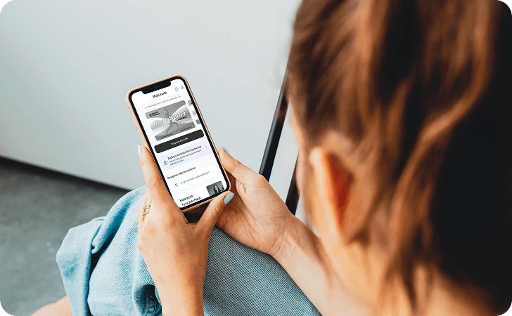Osoba trzymająca smartfon z otwartą aplikacją MultiSport, pokazującą kartę użytkownika. Osoba trzymająca smartfon z otwartą aplikacją MultiSport, pokazującą kartę użytkownika.